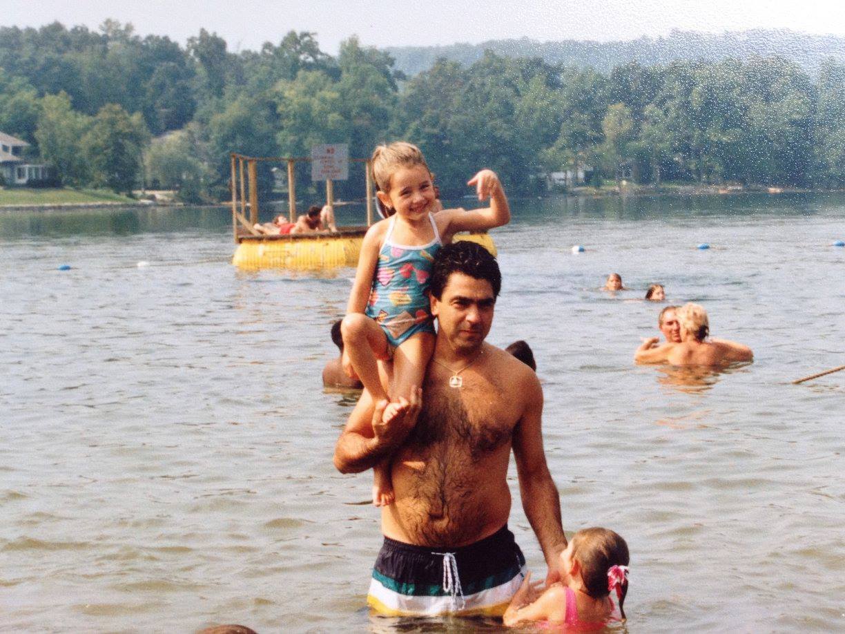 Danielle as a little girl on her father's shoulders in a lake